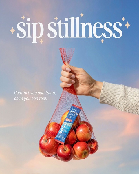 A clean, lifestyle-oriented ad for a mental clarity supplement, featuring a person holding a mesh bag of apples with a single product sachet inside against a serene blue sky.