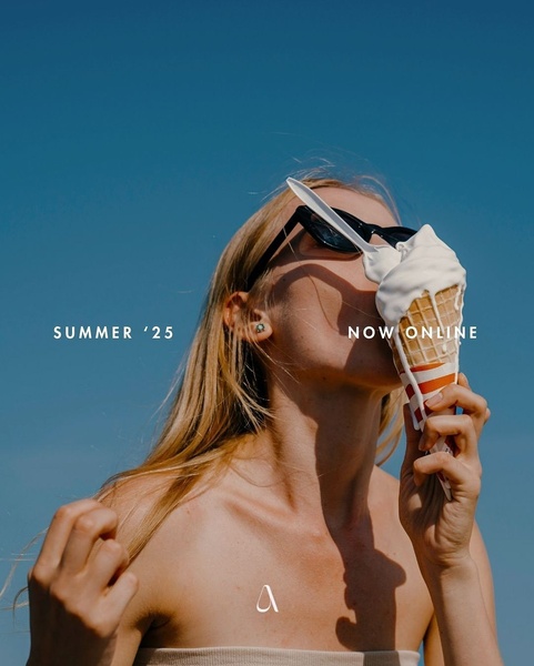 A high-contrast, sun-drenched portrait of a person holding an ice cream cone against a clear blue sky, emphasizing a seasonal, minimalist lifestyle aesthetic.