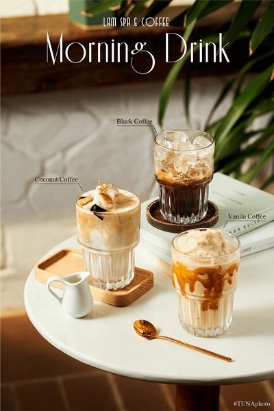 A high-quality lifestyle photograph featuring three distinct coffee drinks arranged on a table, creating a morning-themed aesthetic.