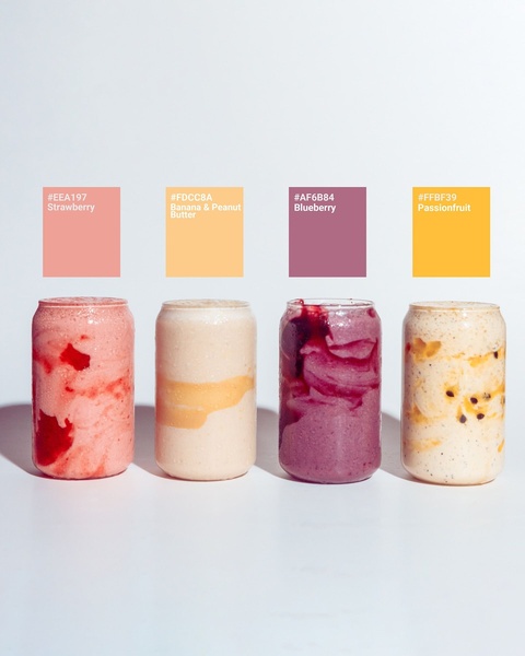 A clean, minimalist studio shot of four different smoothie flavors, each color-coded with corresponding HEX codes to emphasize flavor variety.