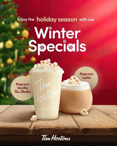 A high-quality product shot featuring a Popcorn Vanilla Tims Shake and a Popcorn Latte set against a festive, red-background Christmas tree scene.