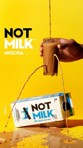 A high-contrast, vertical 9:16 ad featuring a mocha-colored drink being poured into a glass, with the product carton prominently displayed on a vibrant yellow surface.