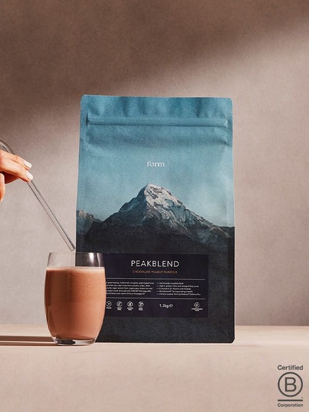 A high-quality, studio-lit shot of a plant-based protein bag with a glass of the prepared drink, emphasizing purity and clean branding.