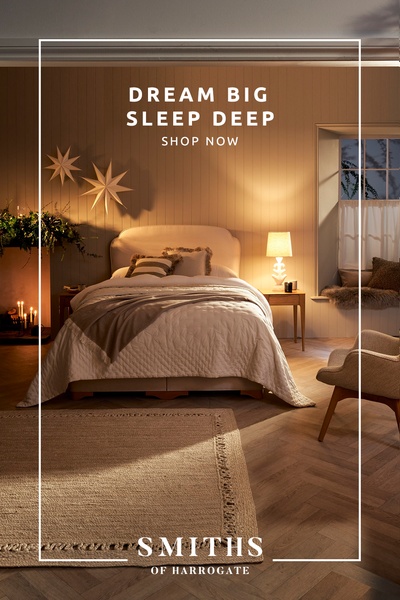 A high-end bedroom scene featuring a minimalist bed setup with warm lighting and soft, neutral tones to evoke comfort.