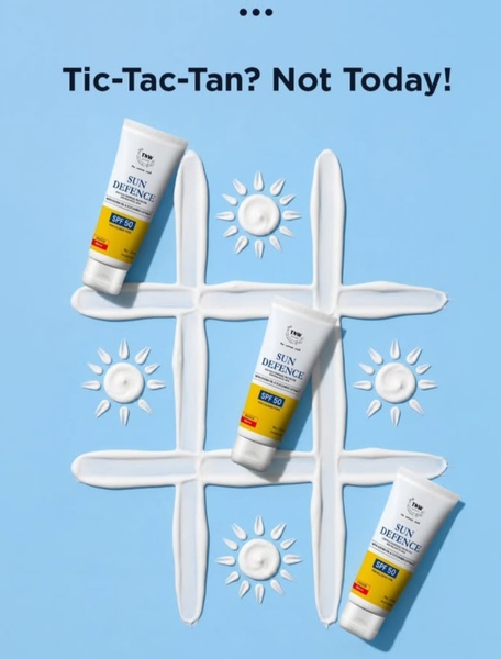 A top-down view of three sunscreen tubes arranged in a tic-tac-toe board made from white lotion on a light blue background.