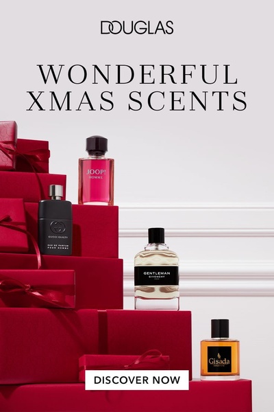 A high-end holiday advertisement showcasing various men's perfume bottles arranged in a tiered pyramid structure with festive red gift boxes.