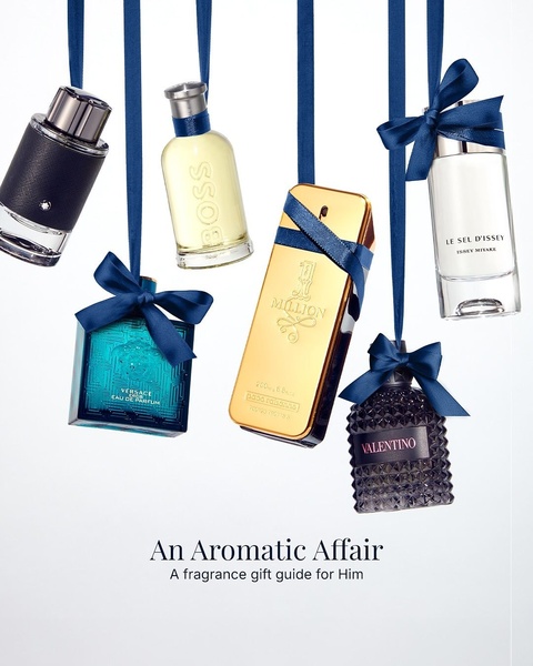 A high-end, seasonal aesthetic displaying multiple bottles of men's fragrance hanging from ribbons to create a gift-ready visual experience.