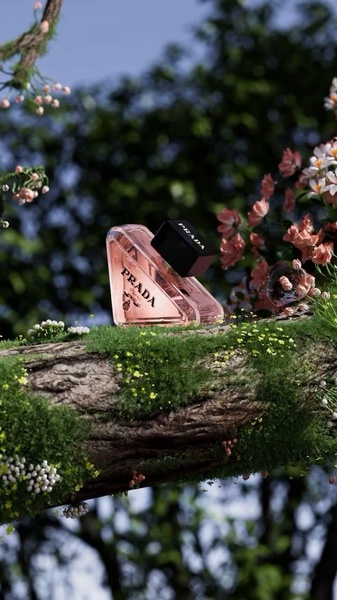 A high-end fragrance bottle set against a natural, moss-covered branch in an outdoor setting, emphasizing organic textures and luxury branding.