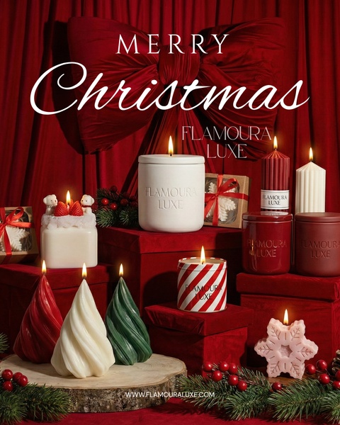 A high-end holiday tabletop display featuring various candles in festive packaging, styled with deep reds and holiday bows.