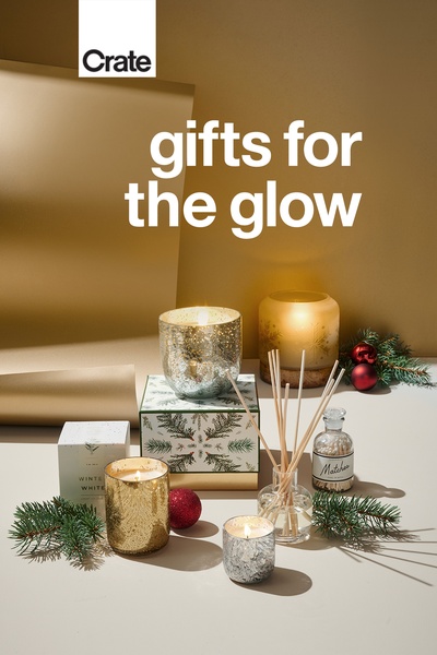 A high-end, seasonal aesthetic featuring candles, reeds, and matchsticks, emphasizing a cozy, warm, and gift-ready atmosphere for the holiday season.