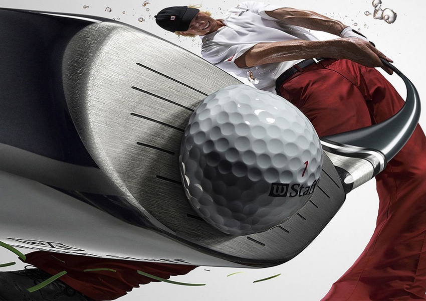 A high-intensity, ultra-close-up image of a golf club hitting a ball, capturing the moment of impact with water splashes and dynamic movement.
