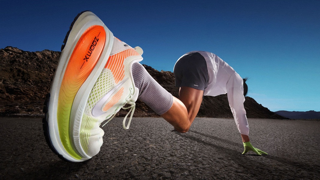 A high-intensity, low-angle shot of a runner launching off a starting point, focusing on the high-tech, brightly colored sole of a running shoe.