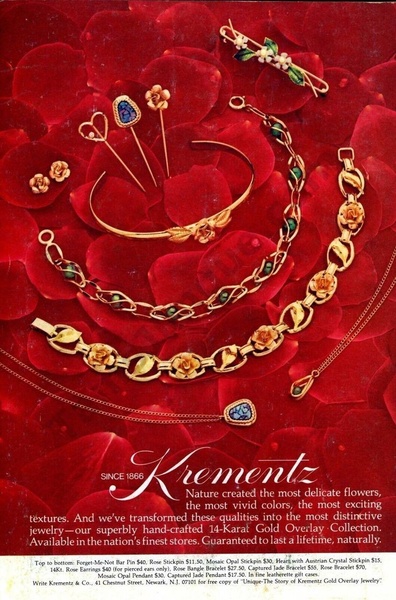 A high-end product display showcasing a collection of gold jewelry pieces arranged aesthetically on a bed of deep red rose petals.