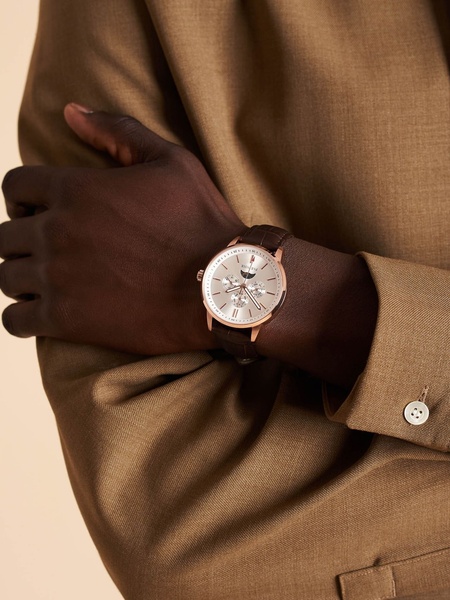wrist watch, analog watch, leather strap watch, men's dress watch, classic watch, brand awareness, lifestyle, editorial, luxurious, trustworthy, brown, neutral