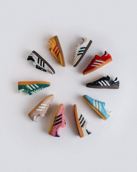 A top-down, symmetrical layout displaying a range of colorful sneakers in a circular pattern against a clean, neutral background.
