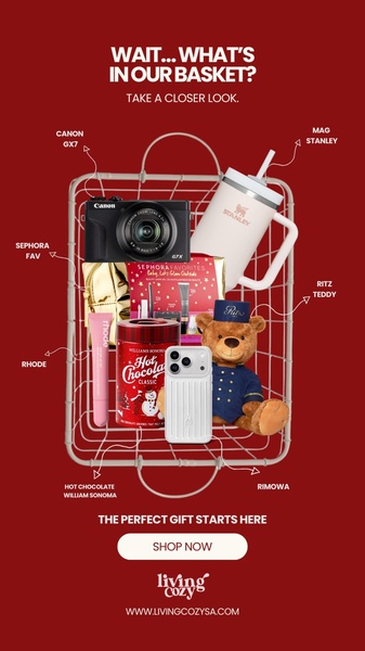 A flat-lay perspective looking down into a wire basket filled with various holiday gifts, featuring a Canon camera, Stanley tumbler, and beauty products.