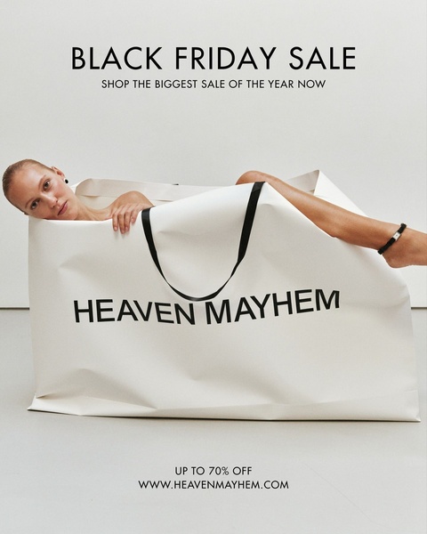 A surrealist photograph featuring a woman inside a giant branded shopping bag, promoting a Black Friday sale.