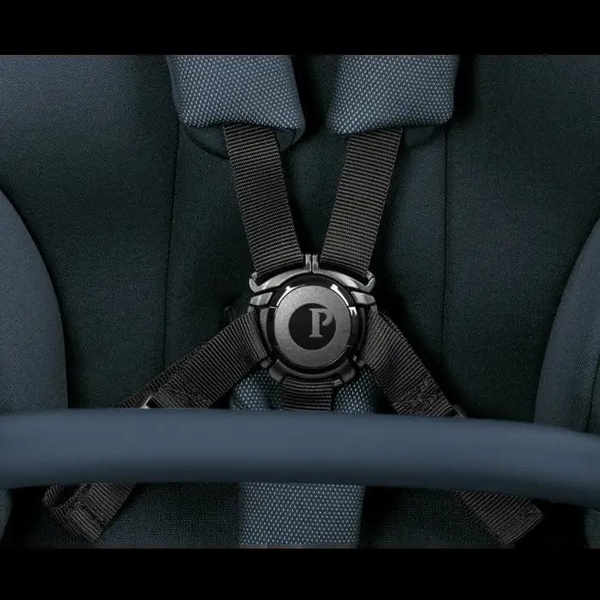 A high-quality close-up shot focusing on the secure five-point harness and buckle system of a baby stroller.