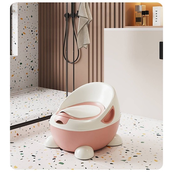 A high-end, clean product shot of a blush and white toddler potty training chair set in a contemporary, neutral bathroom environment.