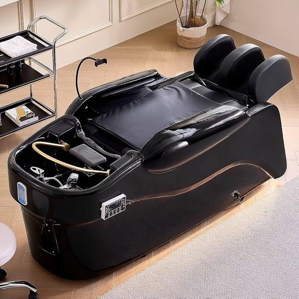 A high-angle studio shot of a premium shampoo bed with a built-in washing station and integrated digital controls, presented in a clean, minimalist salon setting.