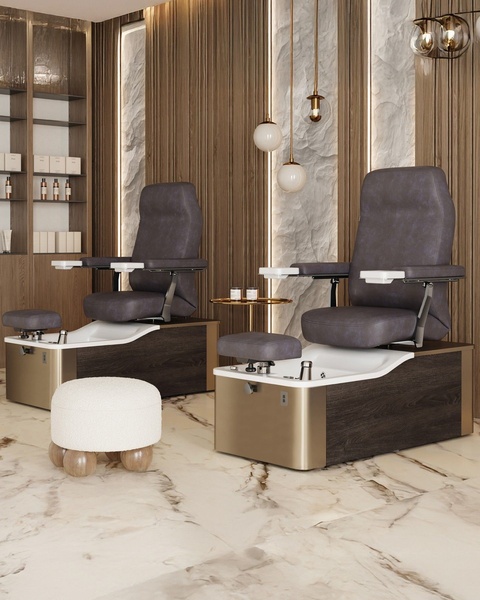 This creative showcases two high-end pedicure chairs in a professionally designed, sophisticated salon environment with warm lighting and marble textures.