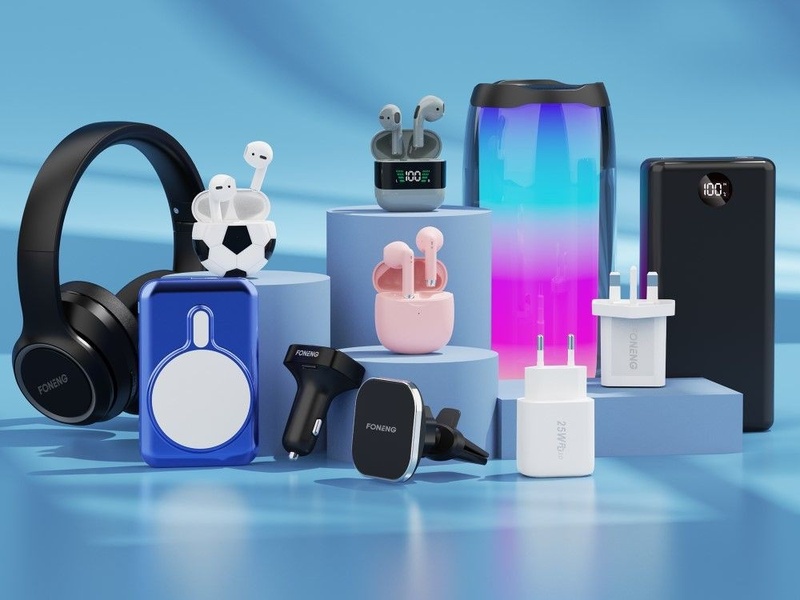A high-quality, studio-style product arrangement featuring headphones, earbuds, chargers, and power banks on a blue pedestal display.