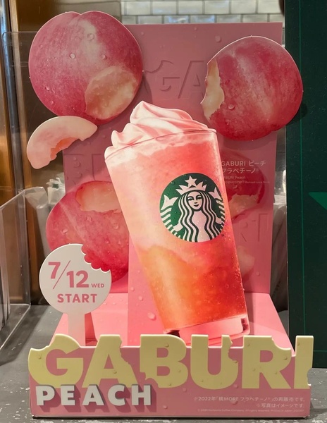 A vibrant, pink-themed promotional display highlighting a seasonal fruit-based beverage with a clear start date.