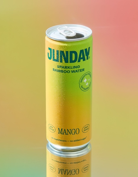 A single can of sparkling bamboo water sits in the center of the frame, lit by a soft, warm gradient background that highlights the product packaging.