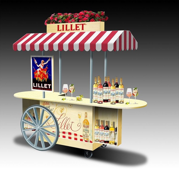 A stylish wooden mobile bar cart featuring Lillet signage, striped awning, and an array of bottled aperitifs and branded glassware for a premium lifestyle feel.