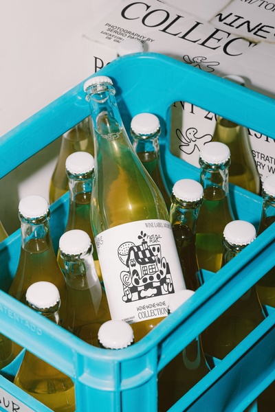 A high-angle shot of multiple glass bottles containing a yellow beverage resting in a bright blue plastic storage crate.