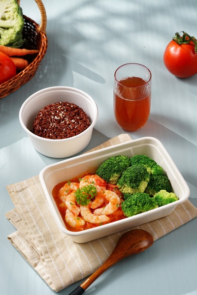 A high-quality, top-down product shot of a healthy shrimp and broccoli meal served with brown rice and a side drink, highlighting meal quality.