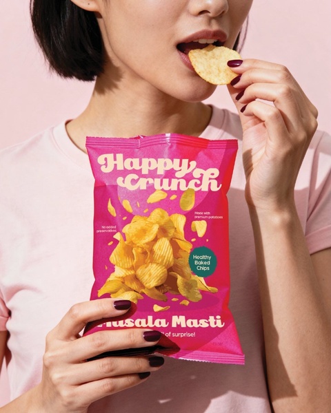 A close-up, high-energy shot of a person eating potato chips, featuring consistent brand color palettes that draw the eye immediately to the product.