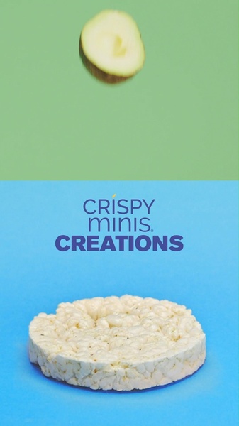 A top-down view showing a single rice cake centered below a falling slice of ingredient, set against a split-screen green and blue background.