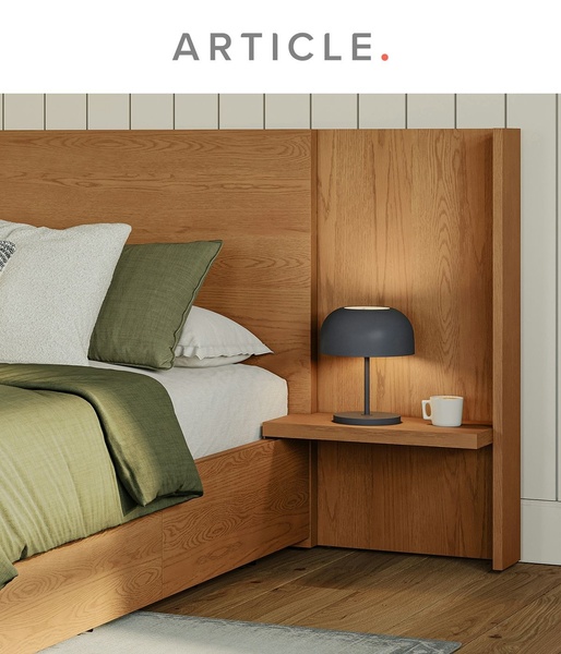 A close-up, high-quality studio shot of a modern wooden bed frame, highlighting textures and integrated shelf features with a calm, editorial color palette.