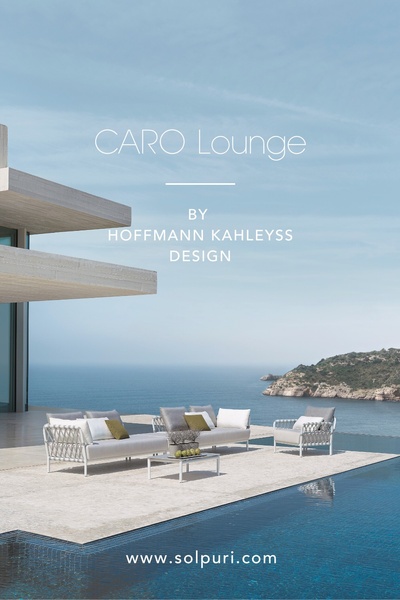 An elegant, high-end outdoor lounge furniture set presented on a modern terrace overlooking the sea, featuring a minimalist and aspirational aesthetic.