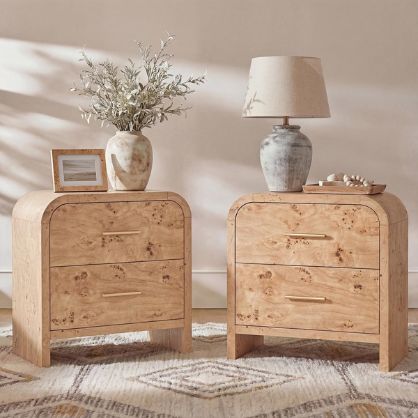 A high-end, symmetrical product shot featuring two identical burl wood nightstands styled in a warm, minimalist bedroom setting.