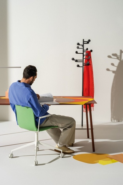 A clean, studio-lit photograph featuring a person working on an office chair, emphasizing color and form.