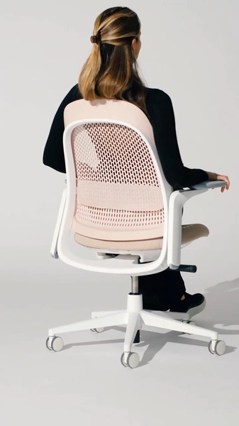 A high-quality studio shot of a person seated on a modern, ergonomic office chair, highlighting the mesh back design and clean aesthetic.