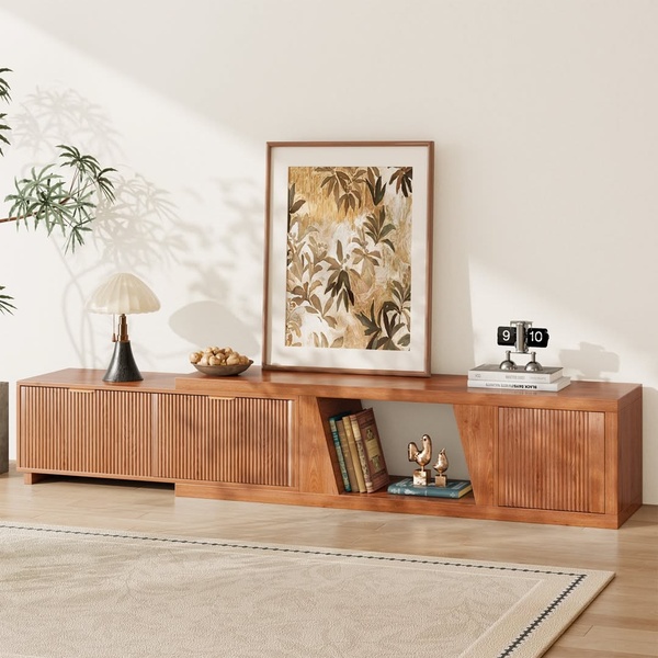 A high-quality studio shot of a long, ribbed-wood media console styled with a modern lamp, abstract wall art, and curated decorative objects.