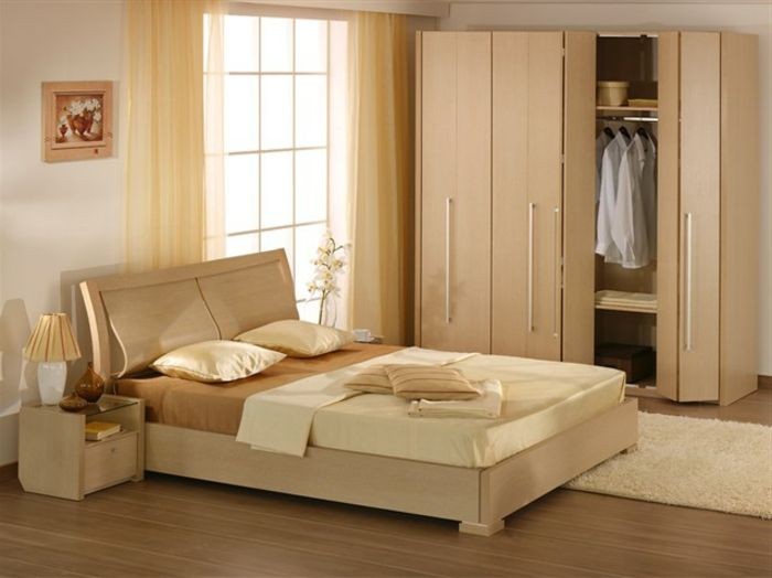 A high-end interior photography shot showcasing a wooden bed frame and wardrobe set in a naturally lit bedroom.