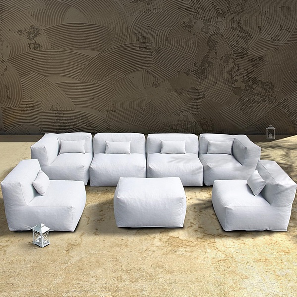 A high-quality, 1:1 image of a modular white sectional sofa arranged in a U-shape on a sand-colored outdoor surface, showcasing clean lines.