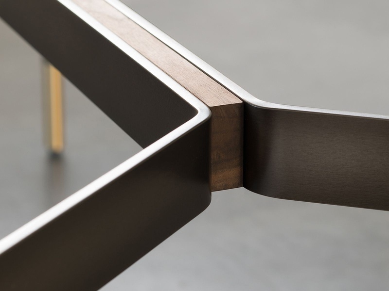 A close-up, high-contrast product shot highlighting the premium joinery and material texture of a modern minimalist coffee table.