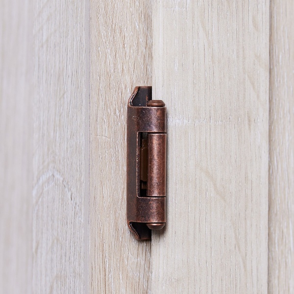 A close-up, high-definition photograph of a bronze-toned cabinet hinge mounted on light-toned oak or wood grain surface.