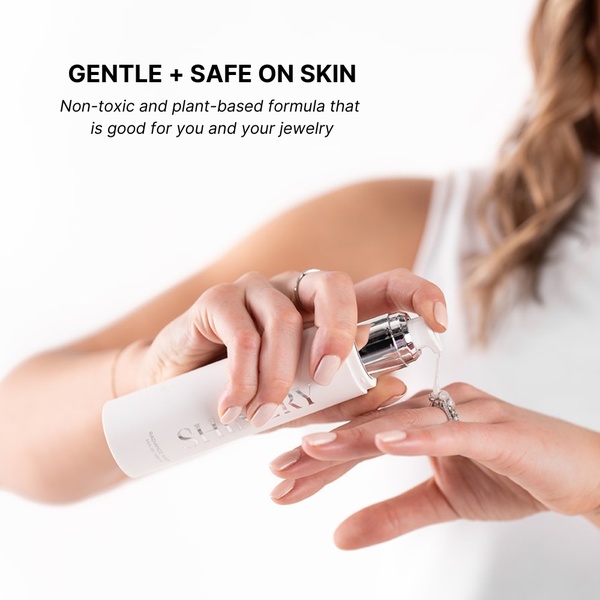 A close-up shot of hands using a plant-based jewelry cleaner bottle to demonstrate safety and ease of use.