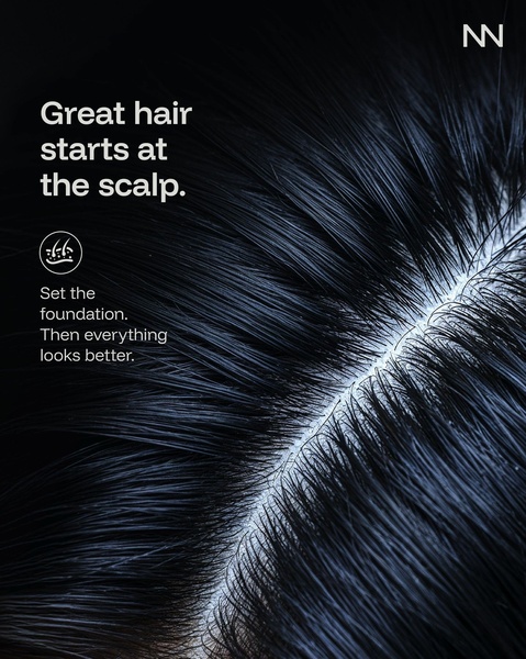 A high-contrast macro shot of a scalp part with bold, direct copy emphasizing that hair health begins at the skin.