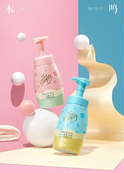 A high-contrast, dual-toned studio shot featuring two bubble shampoo bottles surrounded by floating spheres on a split-color background.
