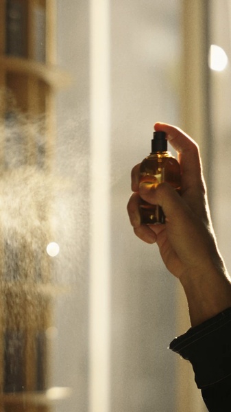 perfume bottle, scent spray, fragrance mist, cologne spray, perfume atomizer, product demo, lifestyle, calm, luxurious, neutral, brown