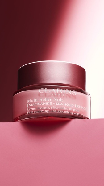 A high-end, clean product shot of a night cream jar featuring deep magenta lighting and soft, focused shadows.