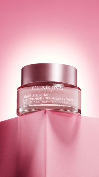 This creative showcases a day cream jar balanced on a geometric pedestal, set against a soft pink gradient background to emphasize a luxury aesthetic.