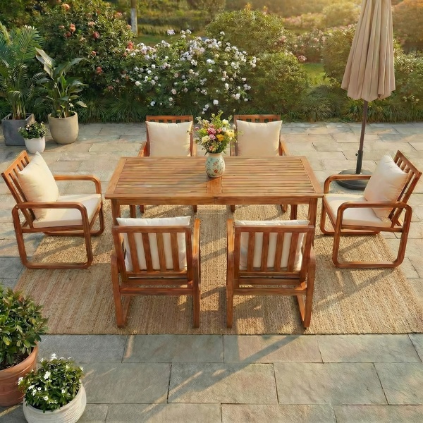 A high-quality lifestyle shot featuring a wooden dining set with cushions in a lush garden setting, focusing on aspirational outdoor living.